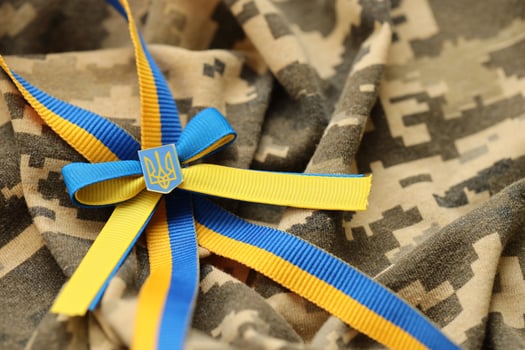 Military camouflage fabric with ukrainian stripes on ribbon photo