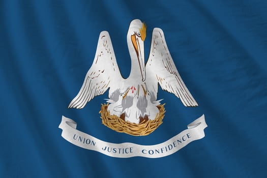 Louisiana US state flag with big folds waving close up under the studio light indoors. The official symbols and colors in banner photo