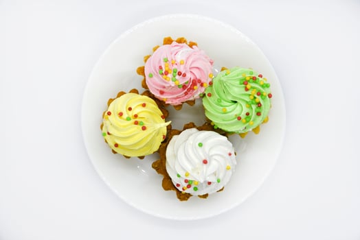 Delicious colorful cakes on a plate. Cream cakes on a white background. Shortbread cakes. photo