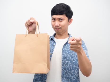 Man holding shopping bag point finger at you photo