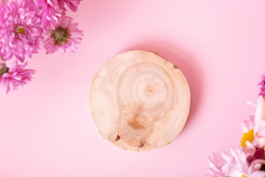 Wooden podium or pedestal with chrysanthemum flowers top view. Mockup for your cosmetic products photo