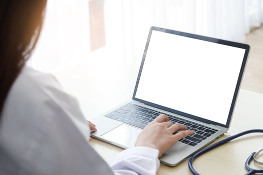 A woman doctor at work typed information on a white screen laptop. Concept of online technology communication. Doctors can examine patients through video calls. Clipping Path photo