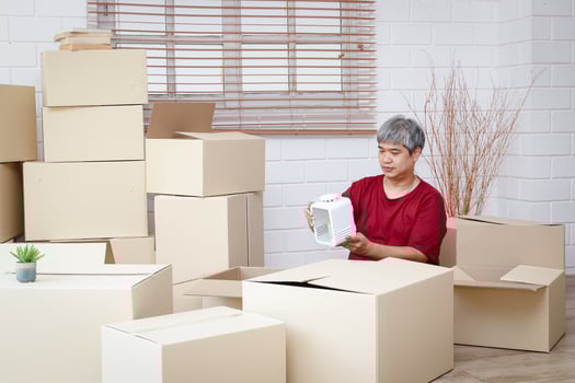 Fat man with white hair is packing products into paper boxes for delivery The concept of small entrepreneurs, online trading business, deliver goods by mail photo