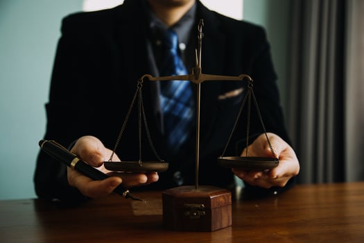 Business and lawyers discussing contract papers with brass scale on desk in office. Law, legal services, advice, justice and law concept picture with film grain effect photo