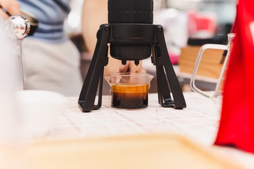 Barista making espresso coffee trought aeropress in cafe. photo
