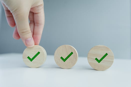 Checklist, Task list, Survey and assessment, Quality Control, Goals achievement and business success. To do list. Hand holding green check mark on wooden circle. photo
