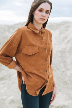 Fashion beauty portrait of young woman in brown organic velvet shirt on the desert background photo