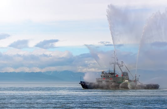 Floating tug boat is spraying jets of water photo