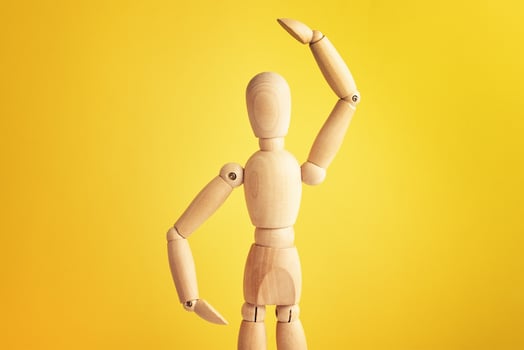 Wooden doll on yellow background photo