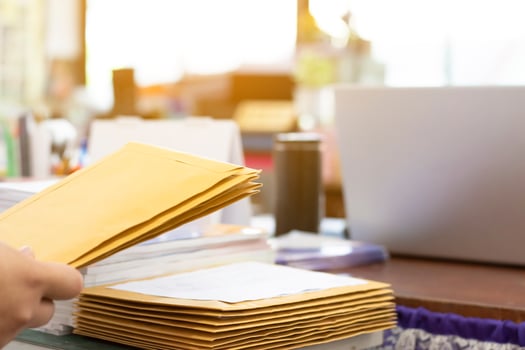 Soft focus of office clerk or secretary is preparing documents and brown envelopes for those interested in bidding for the construction of a large building in an office. photo