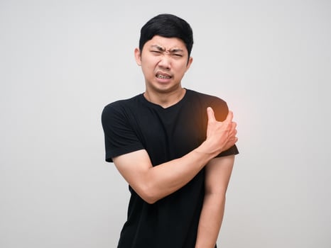 Asian man feels pain his shoulder isolated photo
