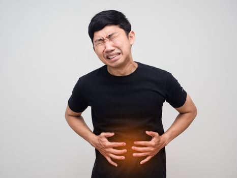 Asian man hold his belly feels very stomach ache isolated photo