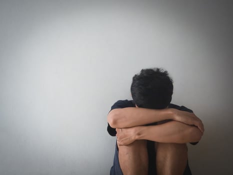 Depressed man sit at the wall feels hopeless with life photo