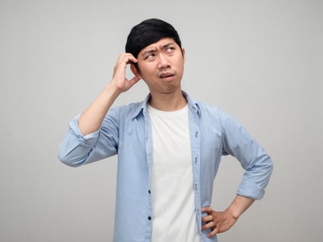 Asian man scratch head feels doubt and hesitate with work isolated photo