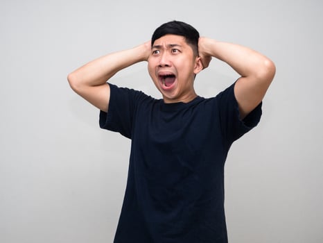 Man black shirt feels amazed hold his head isolated photo