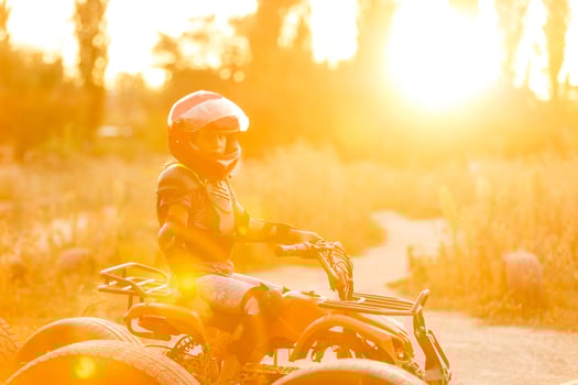 The little girl rides a quad bike ATV. A mini quad bike is a cool girl in a helmet and protective clothing. Electric quad bike electric car for children popularizes green technology. photo