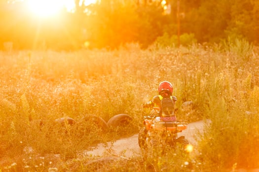 Happy little girl playing on road at the day time. He driving on quad bike in the park. Child having fun on the nature. Concept of happiness. photo