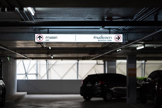 Carparking Lighting box is hung on ceiling. Thai Laungae letter on lighting box at the left side mean EXIT and right side mean No RIGHT TURN photo