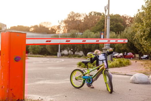 little girl on a bicycle bike near the barrier photo