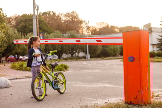 little girl on a bicycle bike near the barrier photo