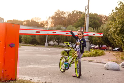little girl on a bicycle bike near the barrier photo