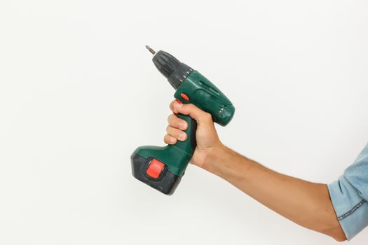 Cordless screwdriver holding by hand with isolated white background. photo