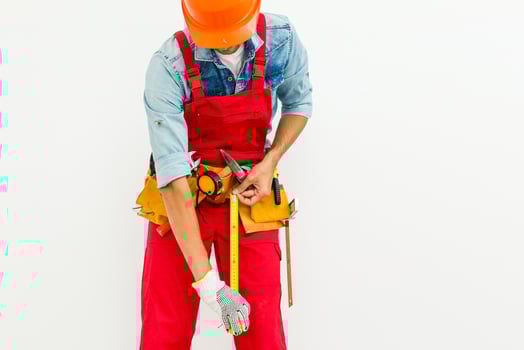 The builder in a helmet with a tape measure photo