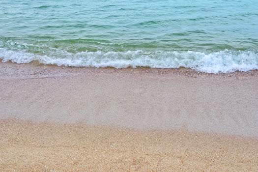 Sea coast and moving wave at the sandy beach for background and inspirational text. photo