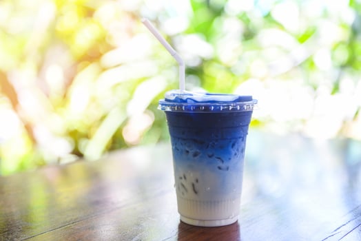 Butterfly pea juice or blue pea flower herbal tea with milk for drink on wooden background photo