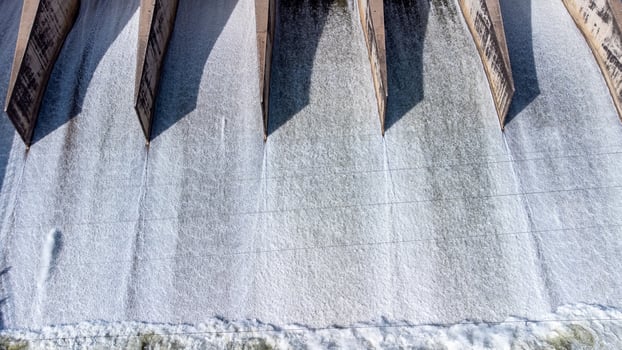 An aerial view over the Pasak Jolasid dam, Lopburi Province, Thailand. Tracking the movement of the floodgates that are releasing water into rural canals in enormous amounts of water. photo