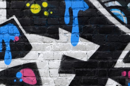 Fragment of graffiti drawings. The old wall decorated with paint stains in the style of street art culture. Colored background texture photo