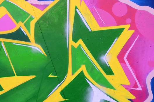 Fragment of graffiti drawings. The old wall decorated with paint stains in the style of street art culture. Colored background texture photo