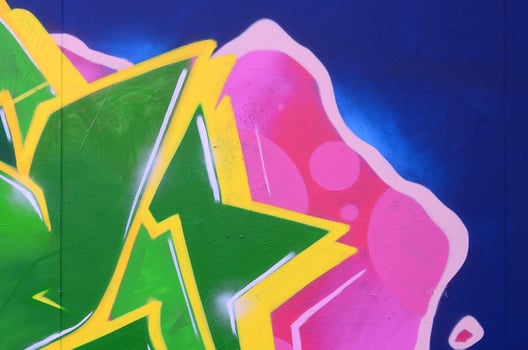 Fragment of graffiti drawings. The old wall decorated with paint stains in the style of street art culture. Colored background texture photo