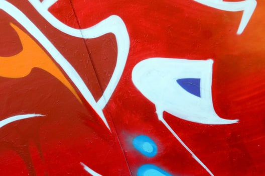 Fragment of graffiti drawings. The old wall decorated with paint stains in the style of street art culture. Colored background texture photo