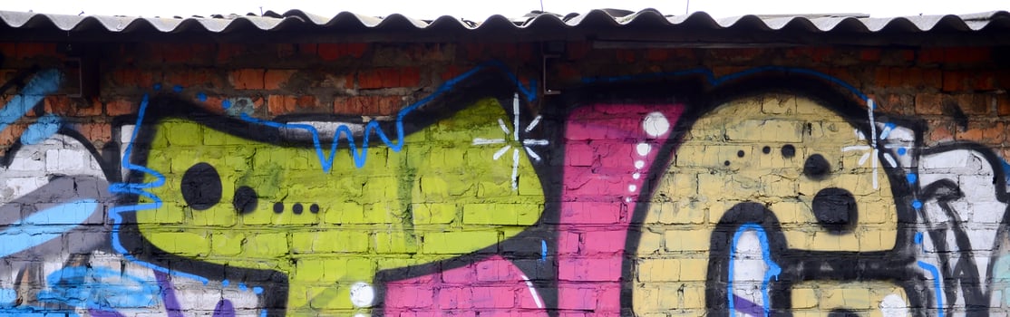 Fragment of graffiti drawings. The old wall decorated with paint stains in the style of street art culture. Colored background texture photo