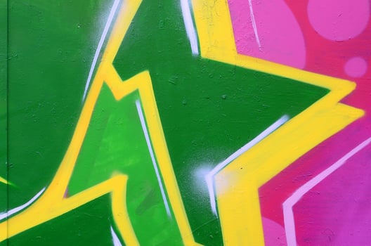 Fragment of graffiti drawings. The old wall decorated with paint stains in the style of street art culture. Colored background texture photo