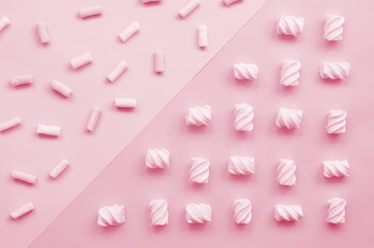 Colorful marshmallow laid out on violet and blue paper background. pastel creative textured pattern. minimal Image toned in Viva Magenta, color of the 2023 year photo