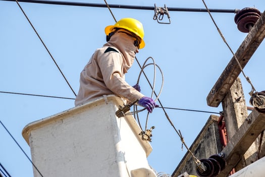 Closeup Electricians working on cable car to repair the power line under light blue sky background. photo