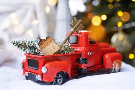 Red retro car with a Christmas tree decorates with the house key in the pickup truck for Christmas. Buying a home, moving, mortgage, loan, real estate, festive mood, New Year photo