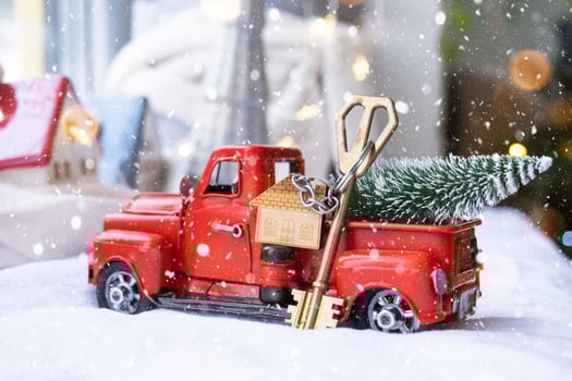Red retro car with a Christmas tree decorates with the house key in the pickup truck for Christmas. Buying a home, moving, mortgage, loan, real estate, festive mood, New Year photo