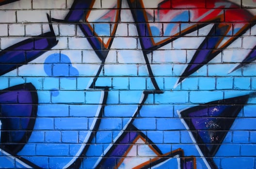 Fragment of graffiti drawings. The old wall decorated with paint stains in the style of street art culture. Colored background texture photo