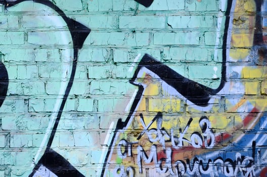 Fragment of graffiti drawings. The old wall decorated with paint stains in the style of street art culture. Colored background texture photo
