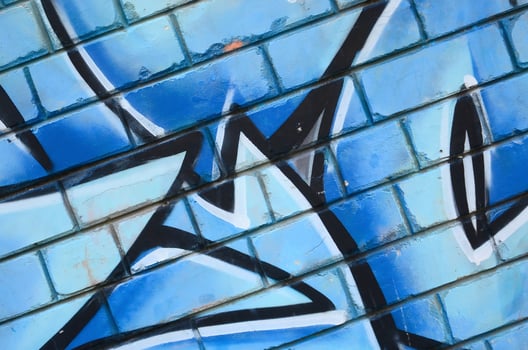 Fragment of graffiti drawings. The old wall decorated with paint stains in the style of street art culture. Colored background texture photo
