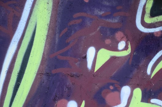 Fragment of graffiti drawings. The old wall decorated with paint stains in the style of street art culture. Colored background texture photo