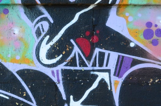 Fragment of graffiti drawings. The old wall decorated with paint stains in the style of street art culture. Colored background texture photo
