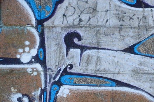 Fragment of graffiti drawings. The old wall decorated with paint stains in the style of street art culture. Colored background texture in warm tones photo