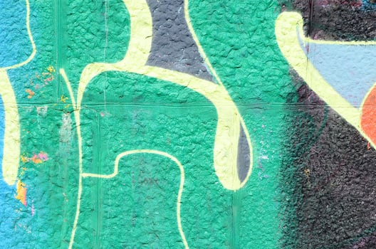 Fragment of graffiti drawings. The old wall decorated with paint stains in the style of street art culture. Colored background texture in green tones photo