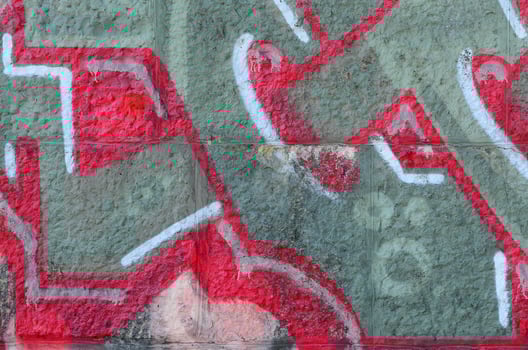 Fragment of graffiti drawings. The old wall decorated with paint stains in the style of street art culture. Colored background texture in warm tones photo