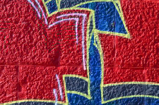 Fragment of graffiti drawings. The old wall decorated with paint stains in the style of street art culture. Colored background texture in warm tones photo