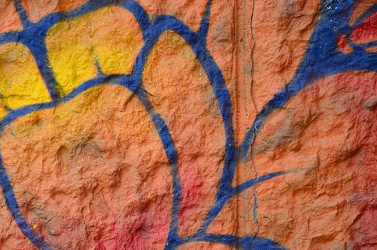 Fragment of graffiti drawings. The old wall decorated with paint stains in the style of street art culture. Orange flower photo